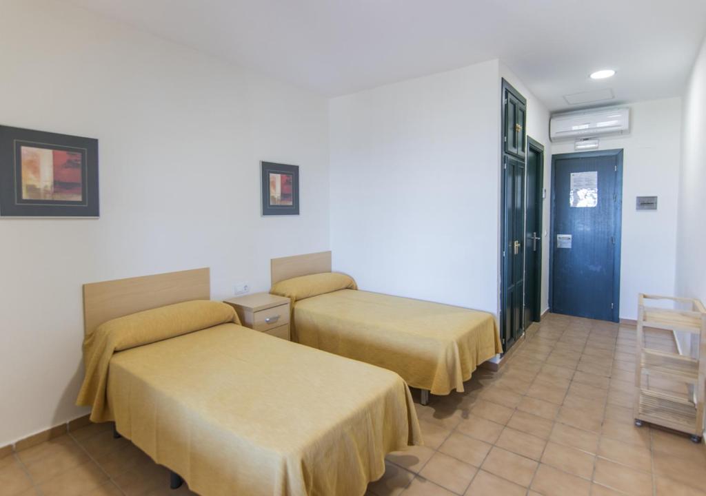 Łóżko lub łóżka w pokoju w obiekcie Albergue Inturjoven Punta Umbría