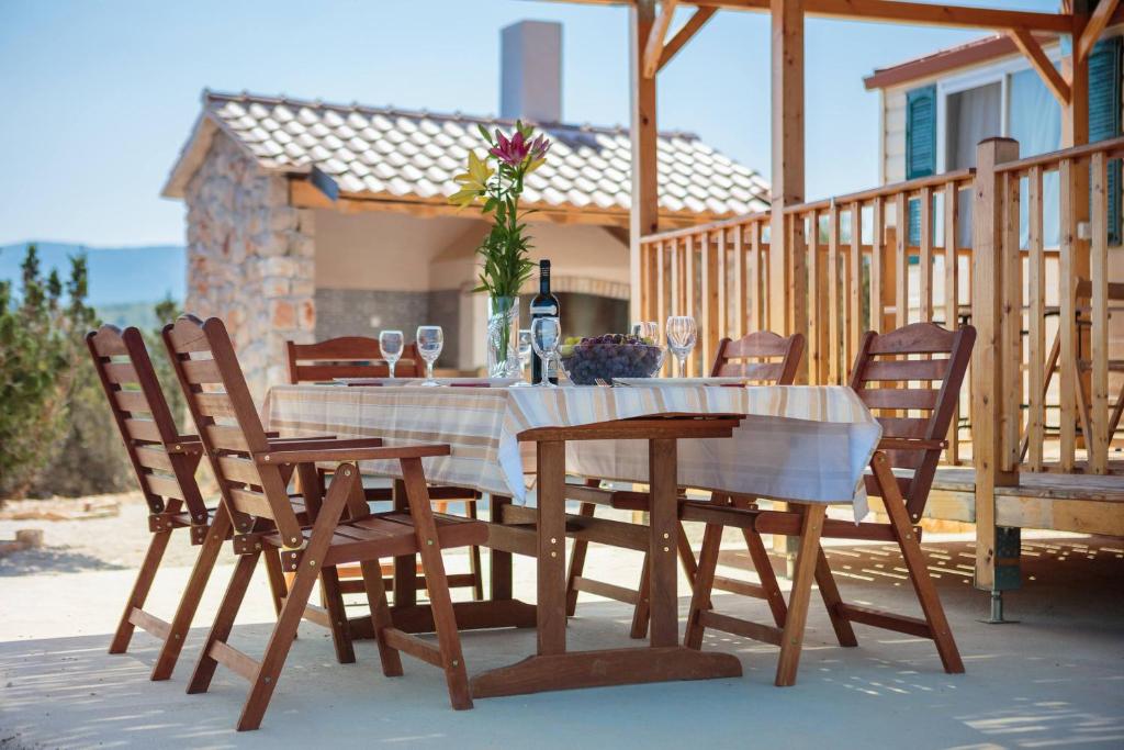 stół i krzesła na tarasie z butelką wina w obiekcie Private Bay Residence w mieście Vrboska