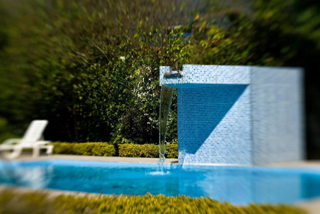 a pool with a water fountain in the middle at Costabela Apart Hotel e Pousada in Ilhabela
