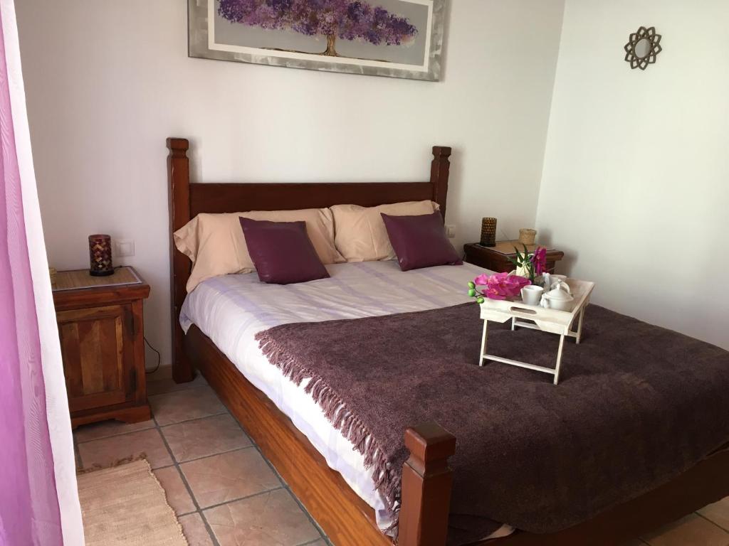 um quarto com uma cama com uma mesa com flores em Casa Daniela em Arrecife