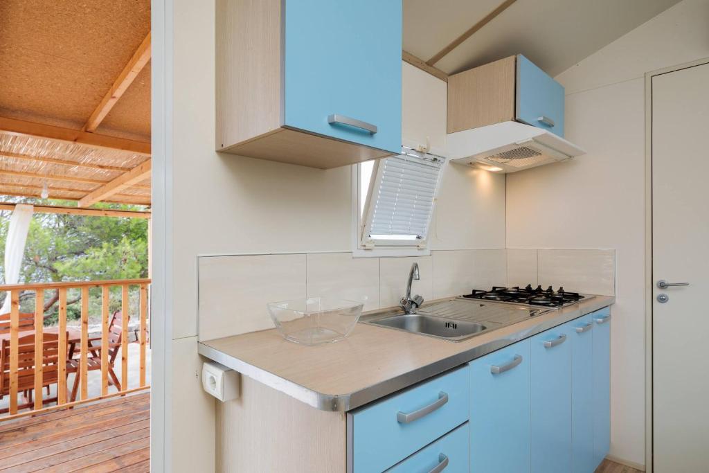kuchnia ze zlewem i kuchenką w obiekcie Private Bay Residence w mieście Vrboska