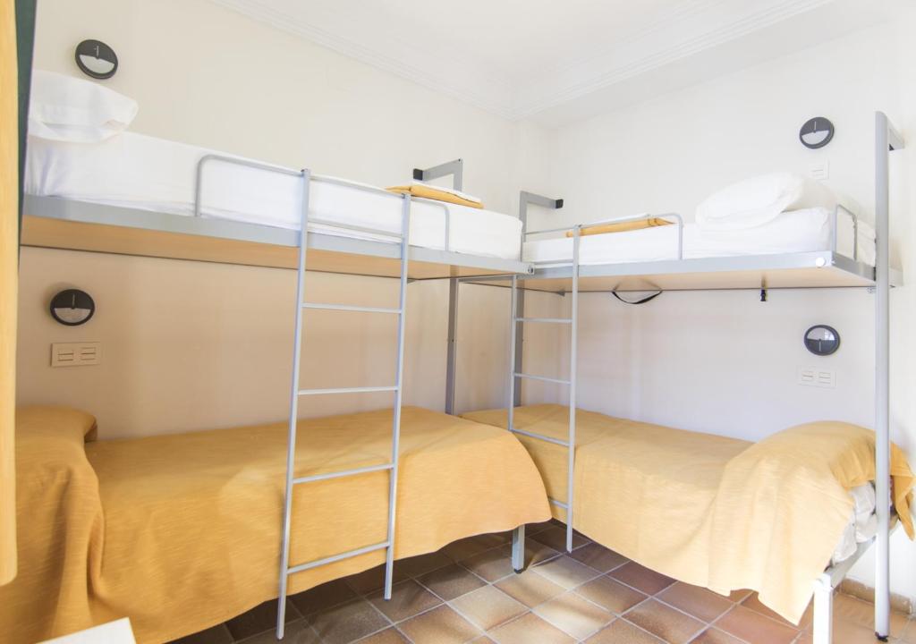 Łóżko lub łóżka piętrowe w pokoju w obiekcie Albergue Inturjoven Punta Umbría