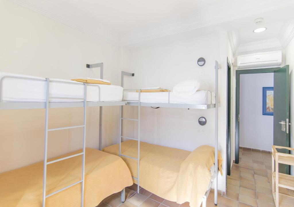 Łóżko lub łóżka w pokoju w obiekcie Albergue Inturjoven Punta Umbría