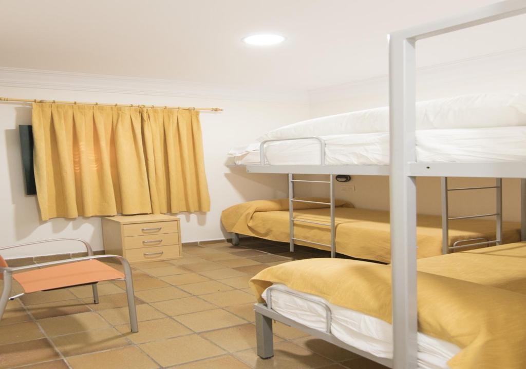 Łóżko lub łóżka w pokoju w obiekcie Albergue Inturjoven Punta Umbría