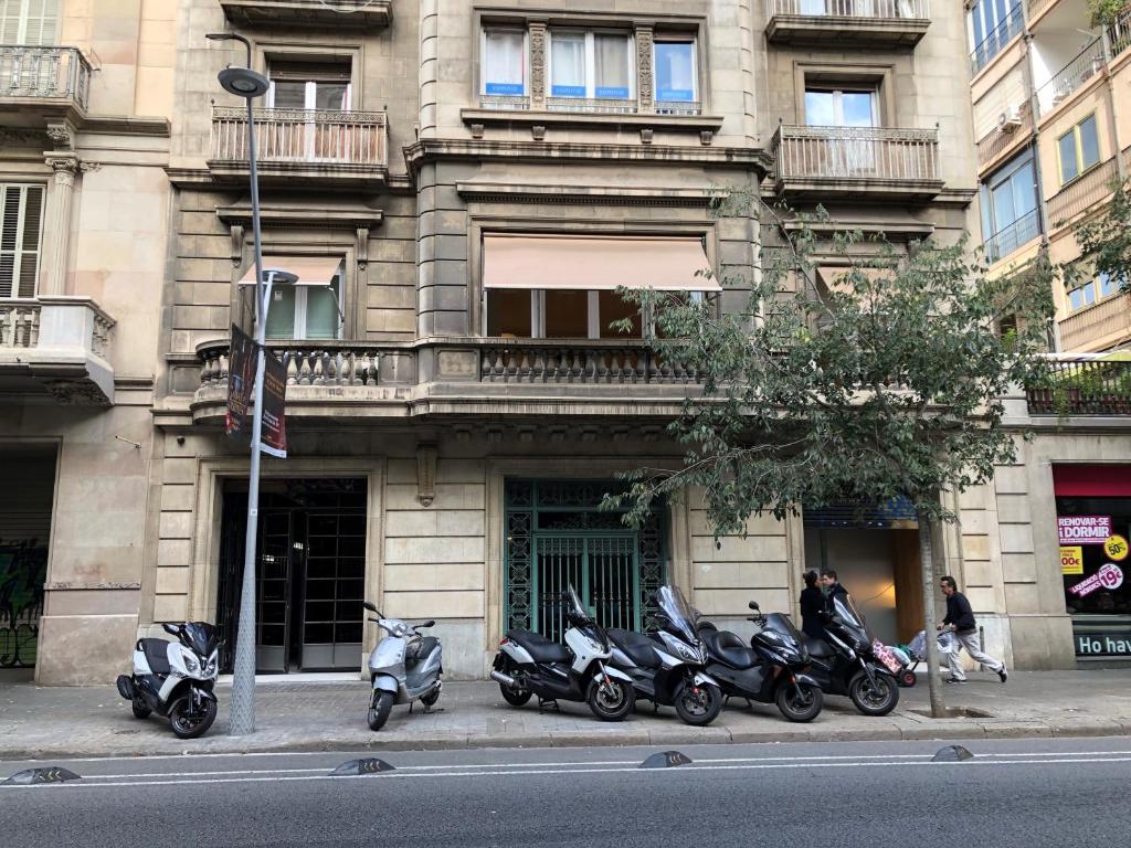 une rangée de motocycles garés devant un bâtiment dans l'établissement Somnio Hostels, à Barcelone