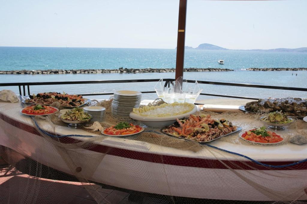 a table with many plates of food on top of the ocean at Grand Hotel Fagiano Palace in Formia