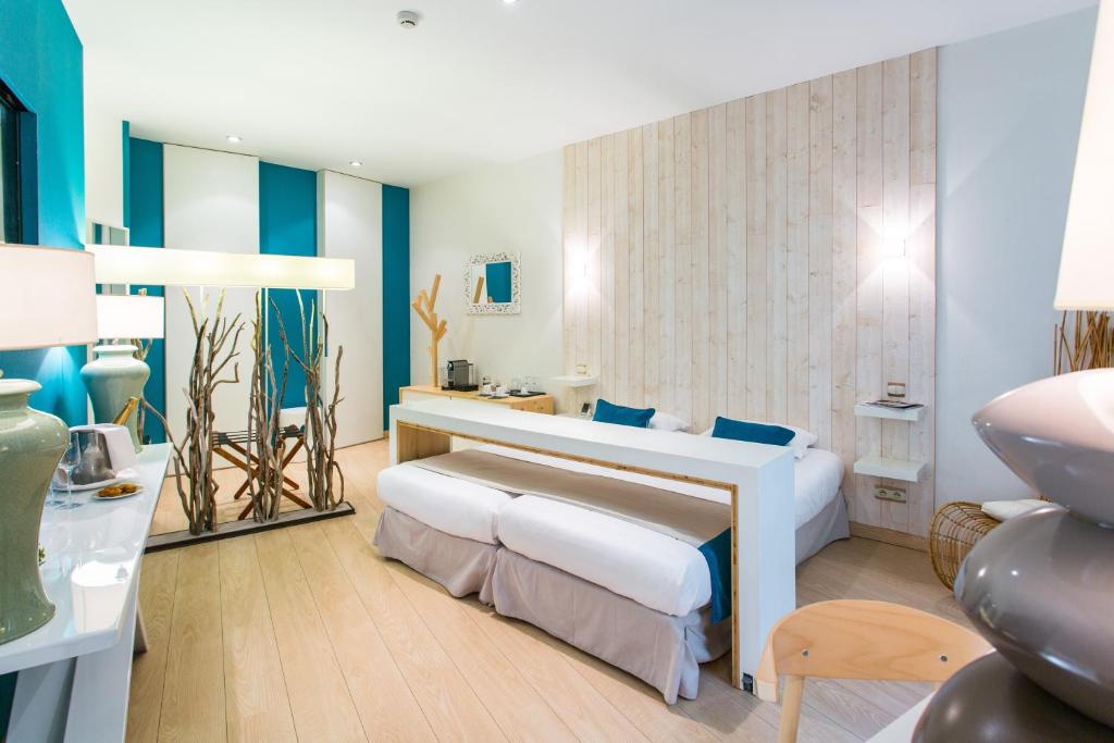 a hotel room with two beds and a table at Résidence des Ducs in Dijon