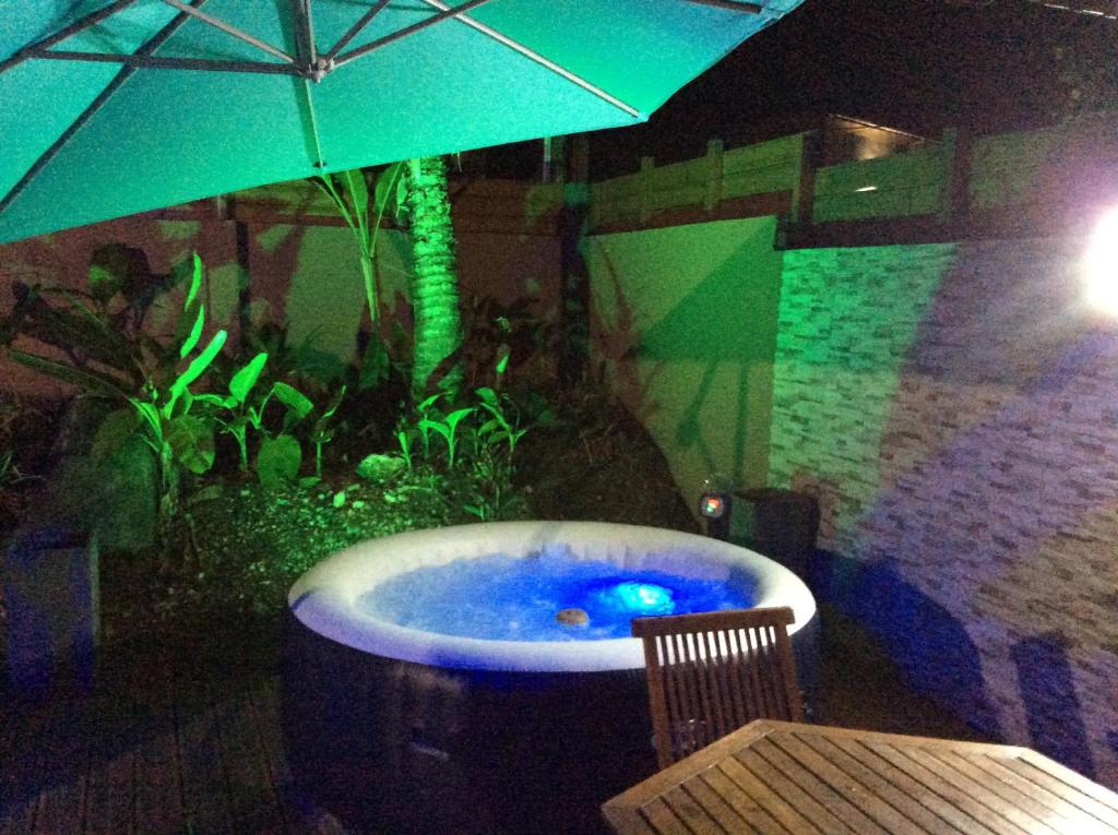 a jacuzzi tub with an aquarium with an umbrella at Bungalow Colibris in Goyave