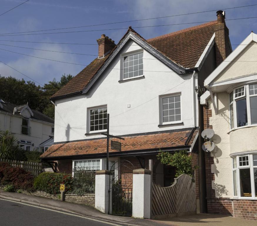 a white house with a brown roof at Devonia Guest House in Lyme Regis