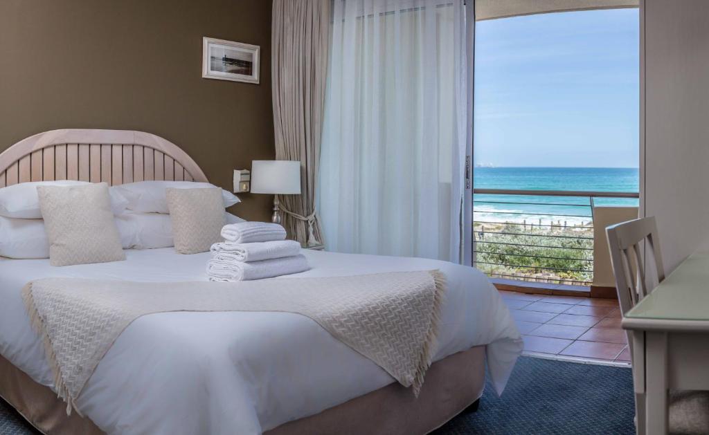a bedroom with a bed with a view of the ocean at Cape Town Beachfront Apartments at Leisure Bay in Cape Town