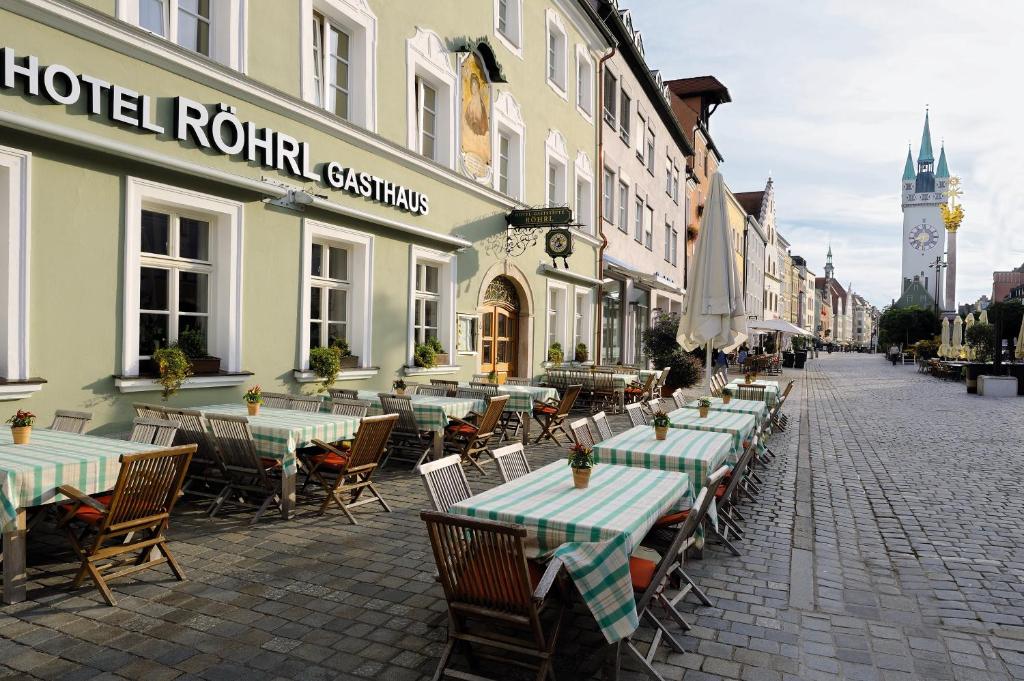 een lege straat met tafels en stoelen en een gebouw bij Hotel & Gasthaus DAS RÖHRL Straubing in Straubing
