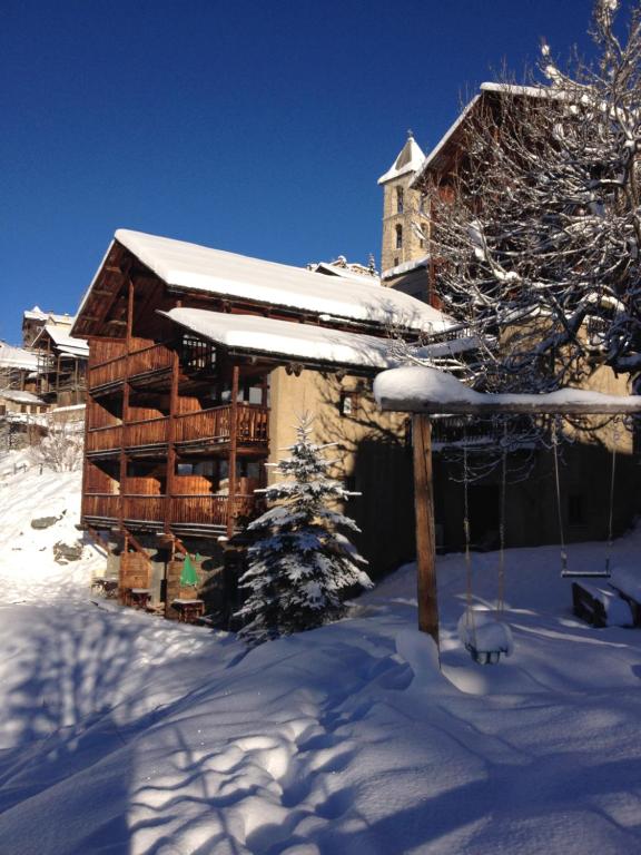 une cabane en rondins dans la neige avec une balançoire dans l'établissement Les Chalets du Villard, à Saint-Véran