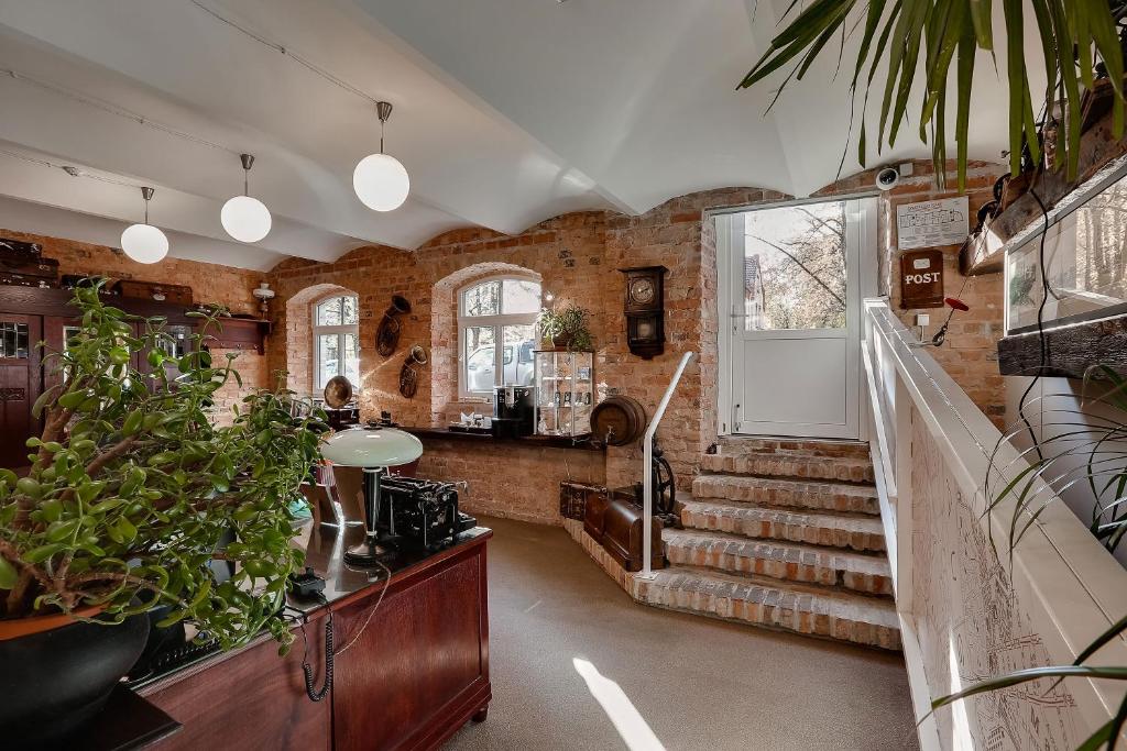 a room with brick walls and stairs with potted plants at Janne Hotel in Rīga