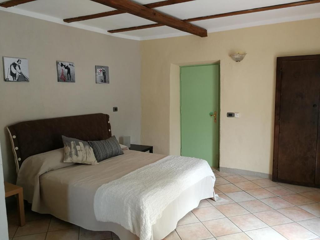 1 dormitorio con cama y puerta verde en Locanda Montecarlo, en Lesegno