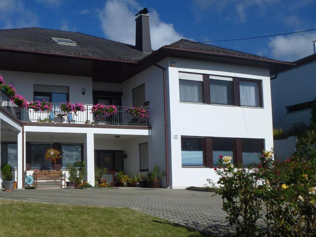 une maison blanche avec des fleurs sur le balcon dans l'établissement Appartment Cerny, à Eisenstadt
