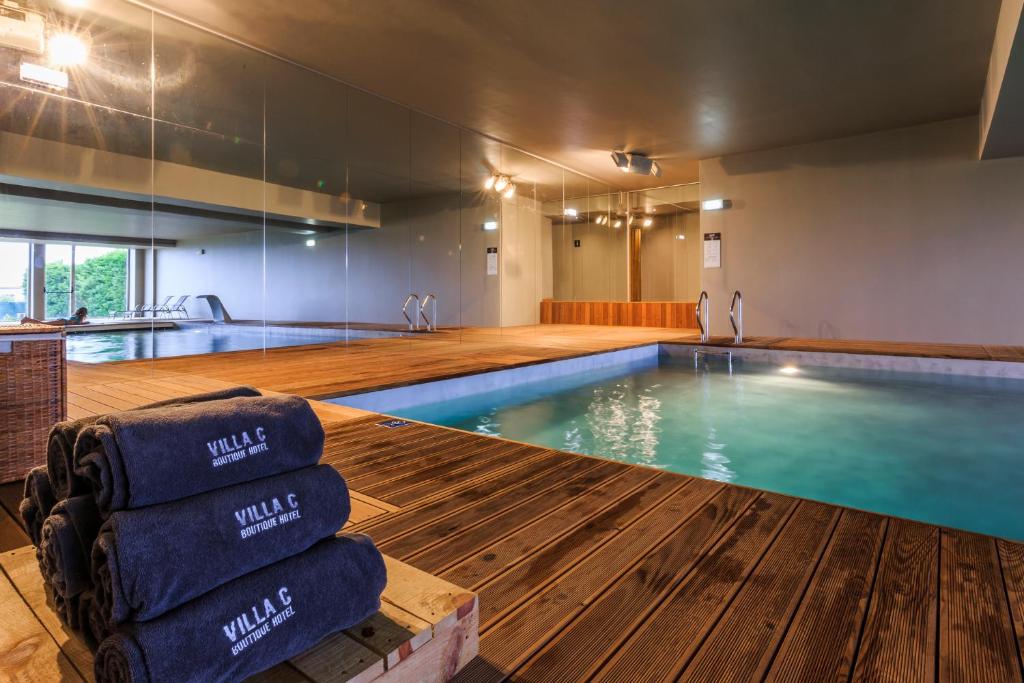 a large swimming pool with blue water in a building at Villa C Boutique Hotel in Vila do Conde