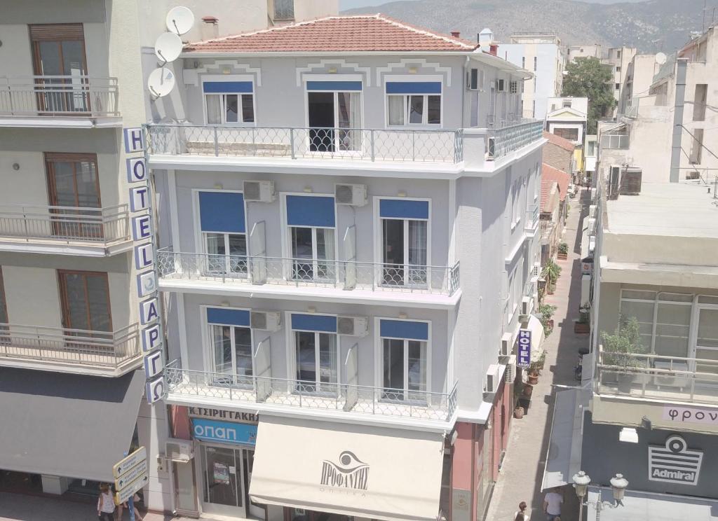 - une vue sur un bâtiment blanc doté de fenêtres bleues dans l'établissement Hôtel Argo, à Vólos
