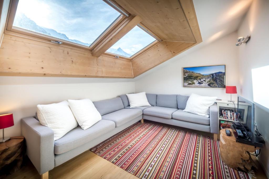 ein Wohnzimmer mit einem Sofa und einem Fenster in der Unterkunft Rupicapra apartment - Chamonix All Year in Chamonix-Mont-Blanc