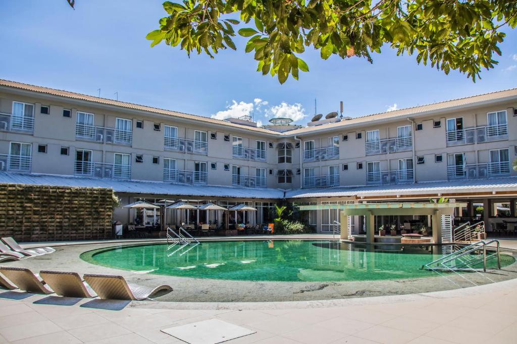 um hotel com piscina em frente a um edifício em Rio Quente Resorts - Hotel Turismo em Rio Quente