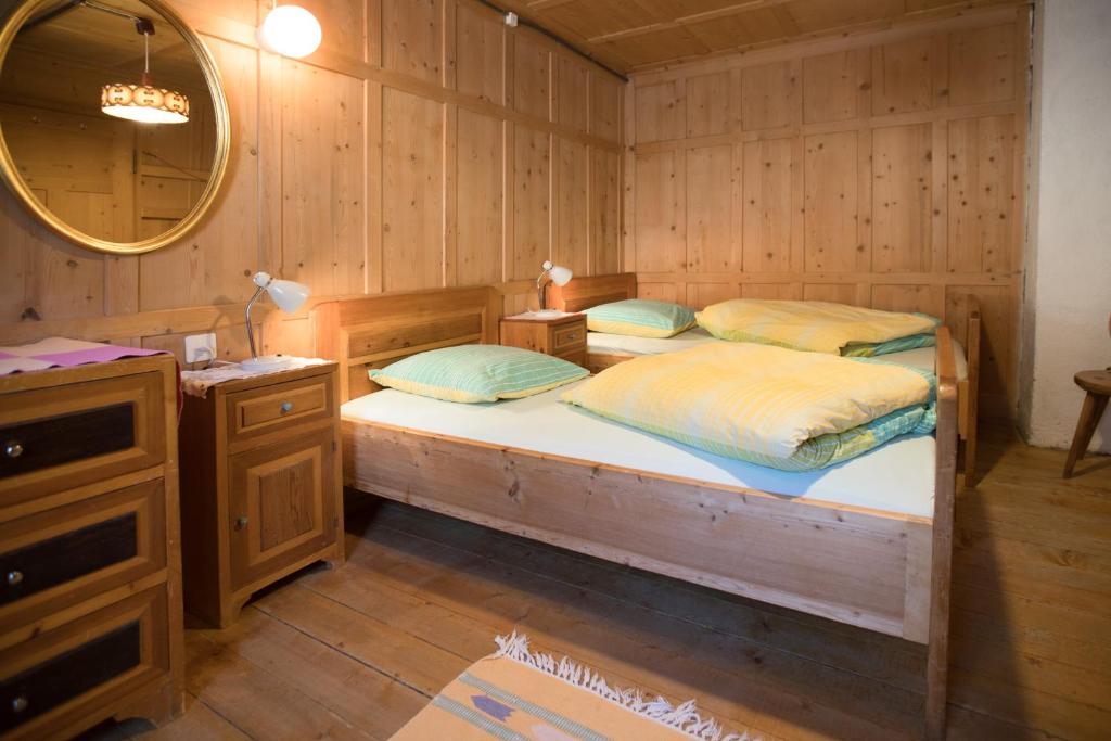 two beds in a room with a vanity and a mirror at Chasa Anguel in Samnaun