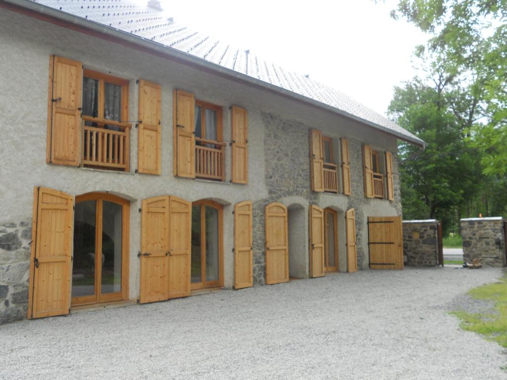 ein Gebäude mit Holztüren und Fenstern darauf in der Unterkunft Maison Josephine in Le Bourg-dʼOisans