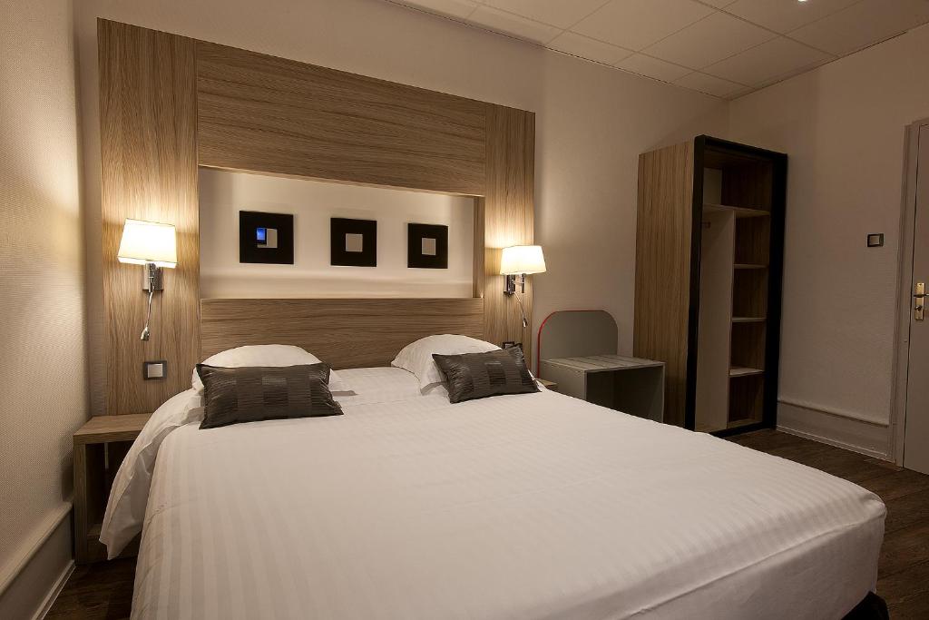 Postel nebo postele na pokoji v ubytování Hôtel le Grillon