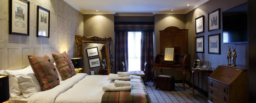 a bedroom with a large bed and a mirror at Forrester Park Resort in Dunfermline
