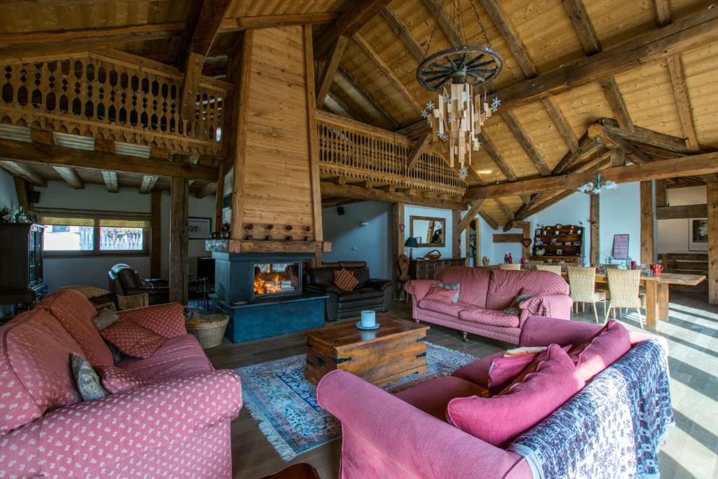 a living room with pink couches and a fireplace at La Ferme du Château in La Chapelle-dʼAbondance