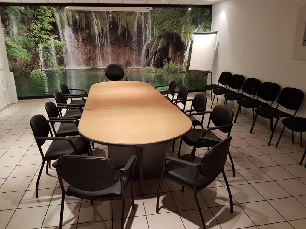 a conference room with a table and chairs in front of a waterfall at Logis Hôtel La Fauceille in Perpignan