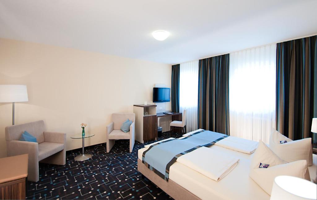 a hotel room with a bed and a desk at Hotel Königer in Pliening