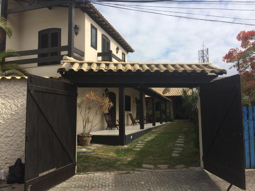 einen Eingang zu einem Haus mit einem schwarzen Tor in der Unterkunft Excelente Casa em Arraial do Cabo in Arraial do Cabo