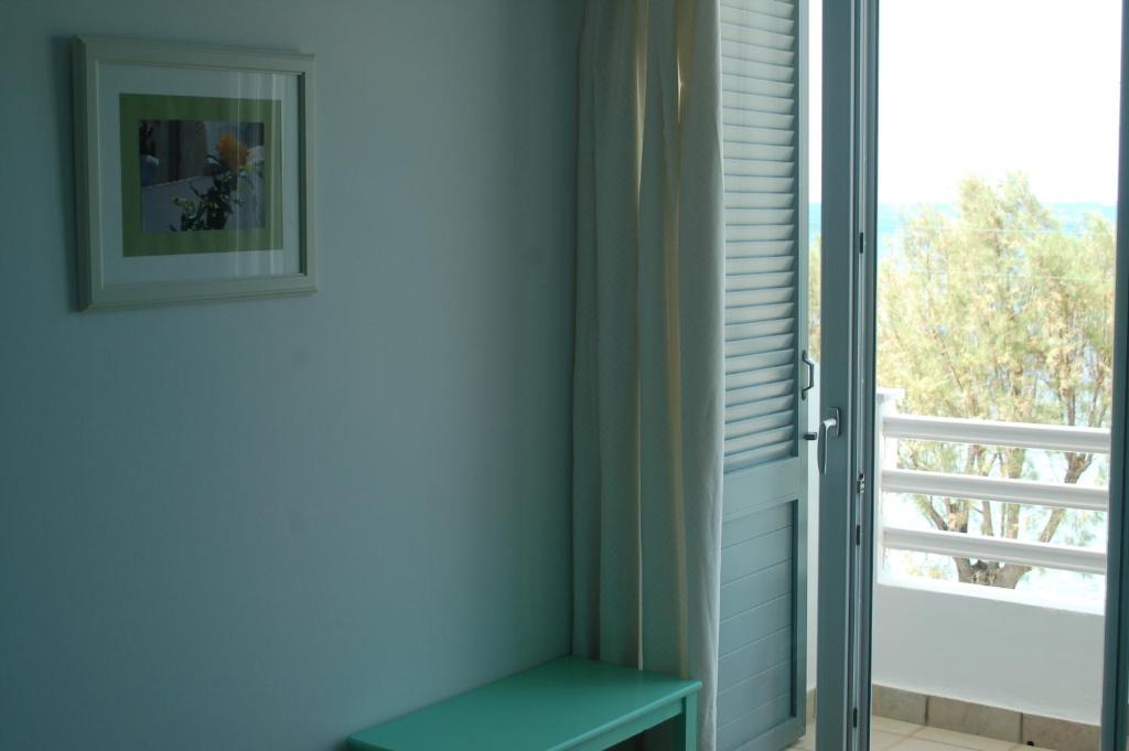 a room with a green bench next to a window at Hotel Paros in Parikia