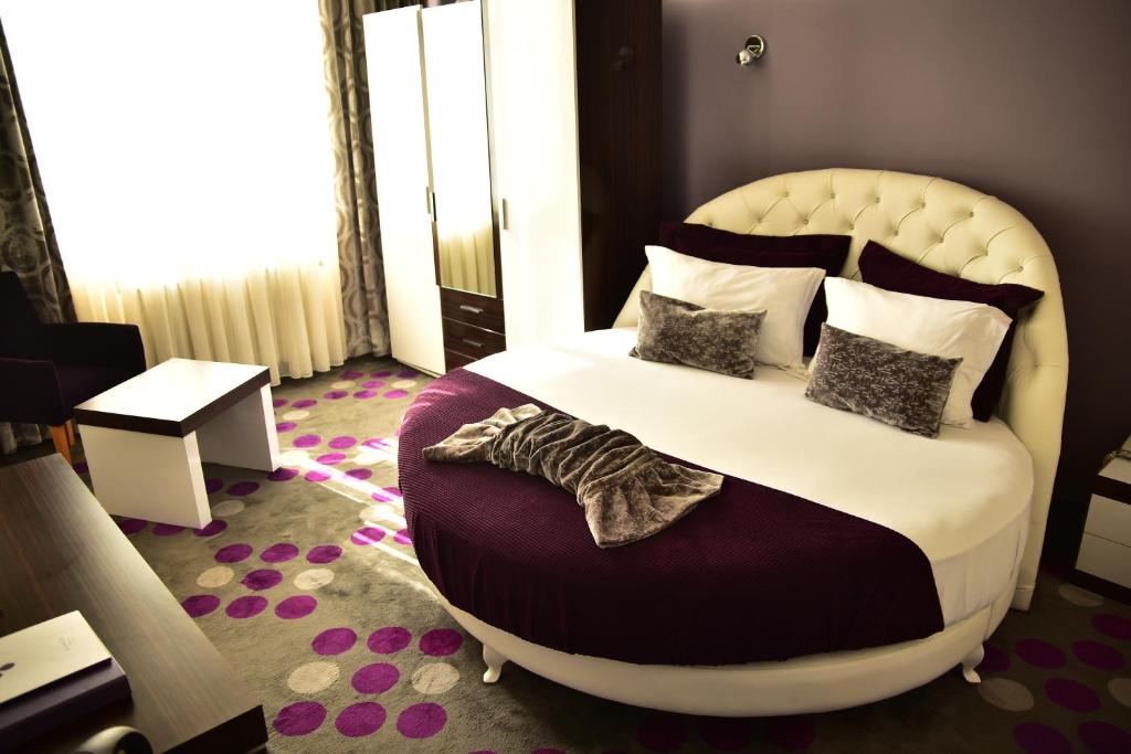 a bedroom with a large bed with pillows at Hande Hotel in Mustafakemalpaşa