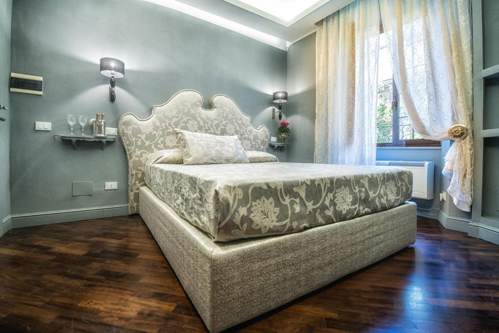 a bedroom with a bed with a large headboard at Hotel Antica Locanda in Rome