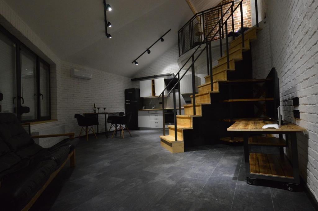 a living room with a staircase and a brick wall at Air Loft Apartment in Kyiv