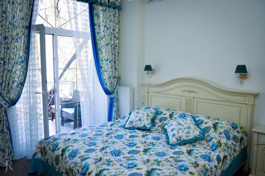 a bedroom with a bed with pillows and a window at Hotel MAMAN in Odesa