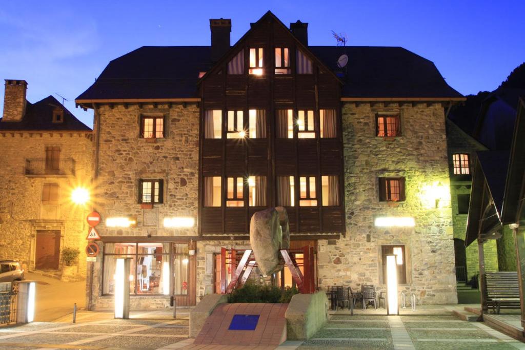 a large building with a statue in front of it at Hotel-Aparthotel El Reyno in Sallent de Gállego