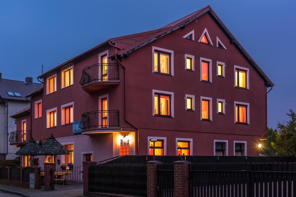 een groot rood gebouw met lichten aan bij Dom Wypoczynkowy Admirał in Łeba