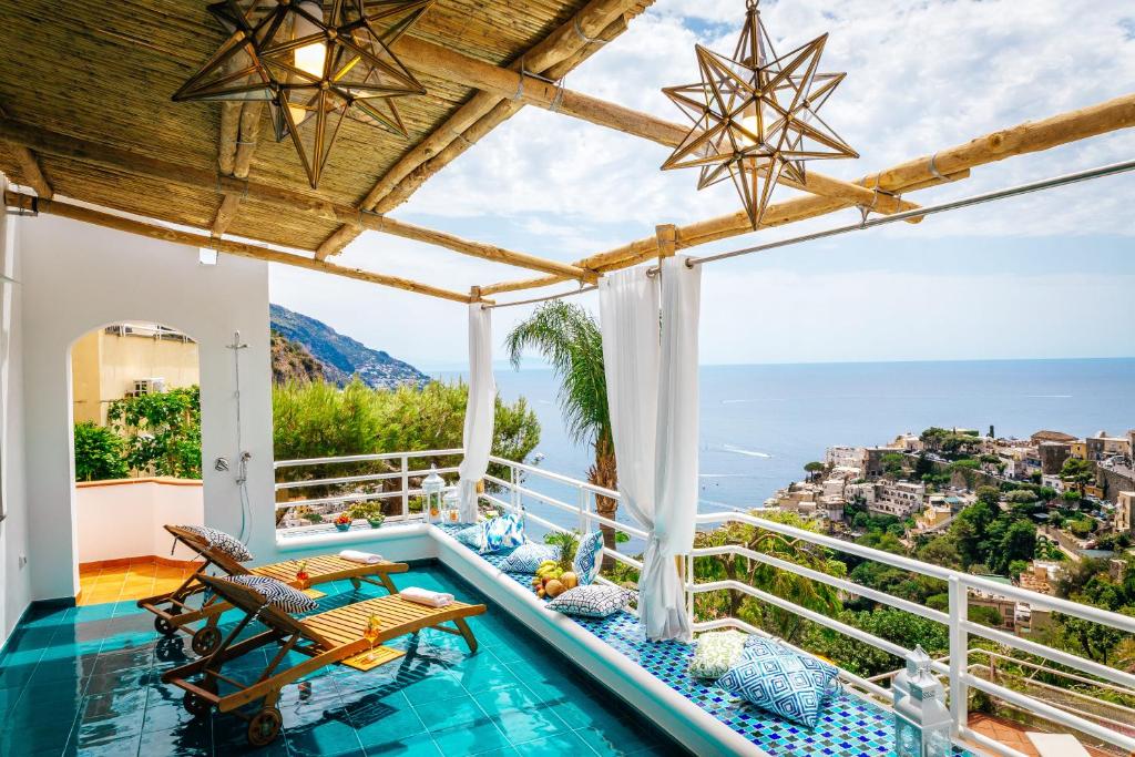 
a beach area with a pool, chairs, and a balcony at Eden House Positano in Positano

