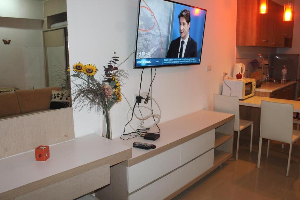 een woonkamer met een tv aan de muur bij Studio in Haven in Bangkok