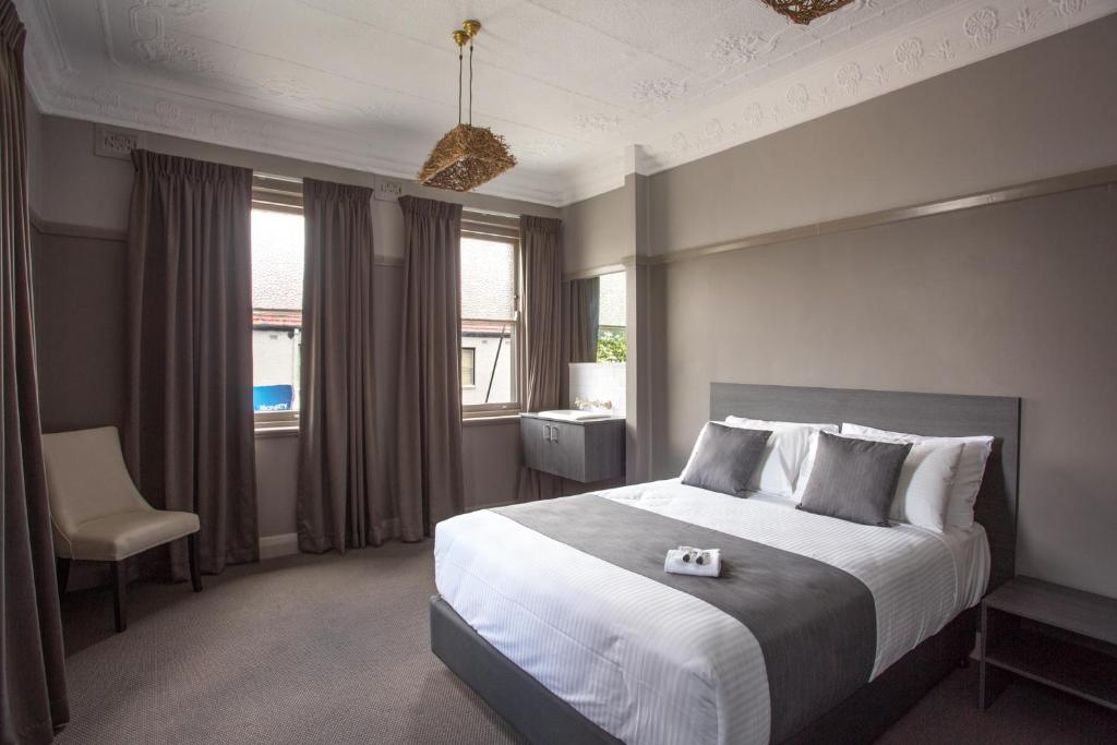 um quarto com uma cama grande e uma cadeira em Nags Head Hotel em Newcastle