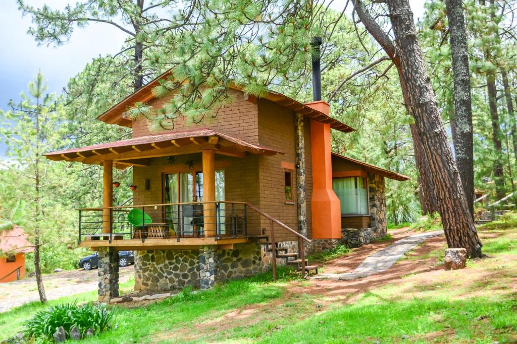 a house in the woods with a wrap around porch at Monterra Tapalpa in Tapalpa