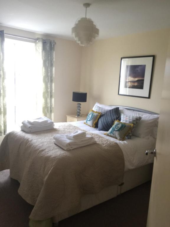 a bedroom with a bed with towels on it at Sky Night Serviced Apartments in Cardiff