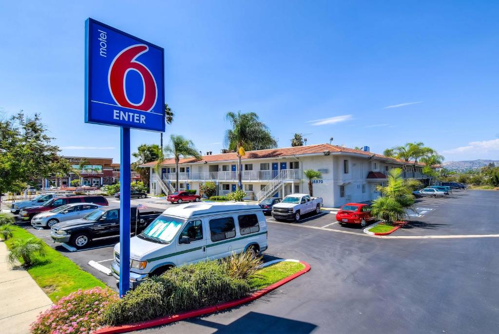 una señal para un concesionario de coches en un estacionamiento en Motel 6-Rowland Heights, CA - Los Angeles - Pomona, en Rowland Heights