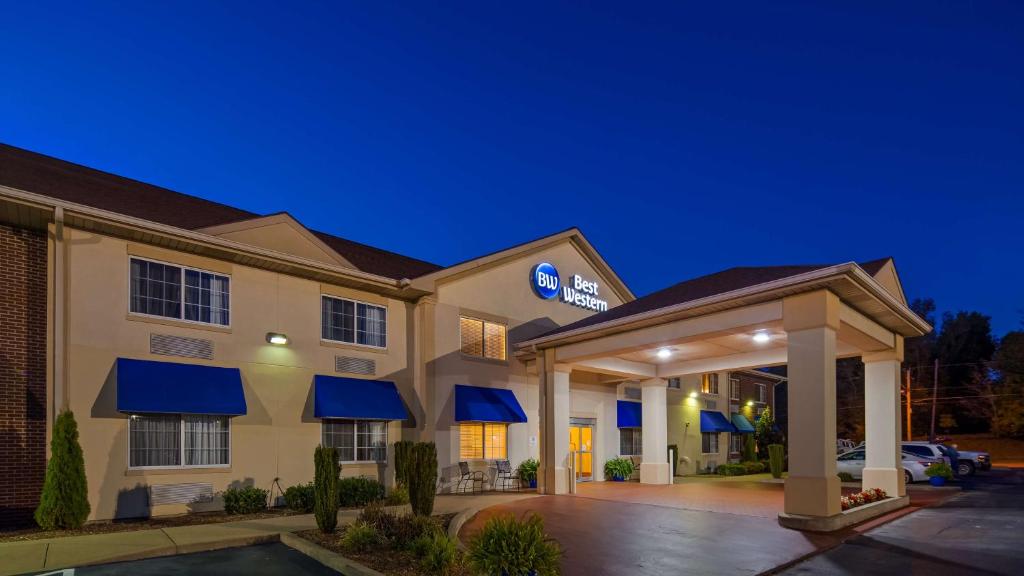 a hotel with blue awnings in a parking lot at Best Western Central City in Central City