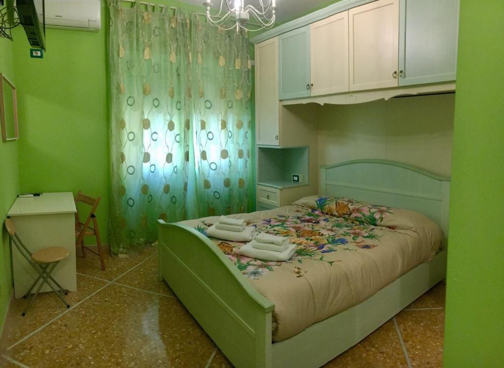 ローマにあるAppartamenti Romolo E Remoの緑のベッドルーム(タオル付きのベッド付)