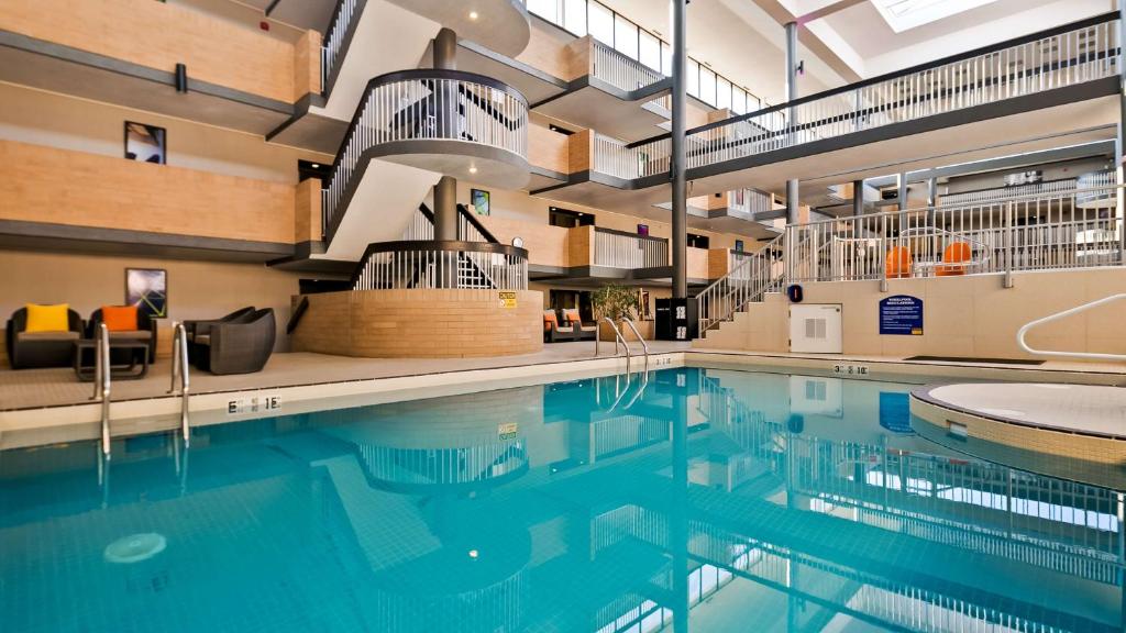 a large swimming pool with a clock on the wall at Best Western Plus Village Park Inn in Calgary
