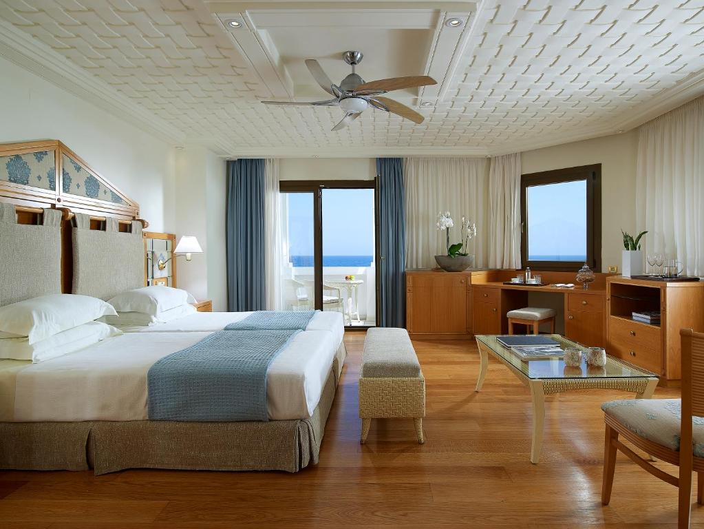 1 dormitorio con cama, escritorio y mesa en Aldemar Knossos Villas, en Hersonissos