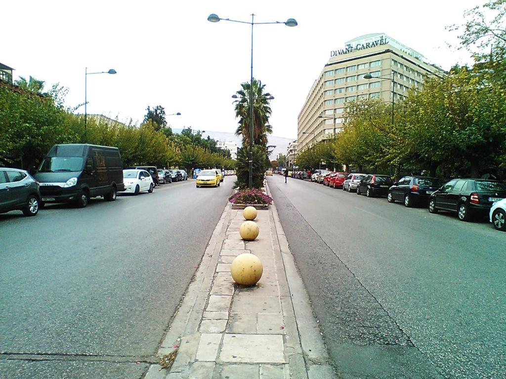 a street with cars parked on the side of the road at Tranquil Central Apt, behind Athens Caravel Area in Athens