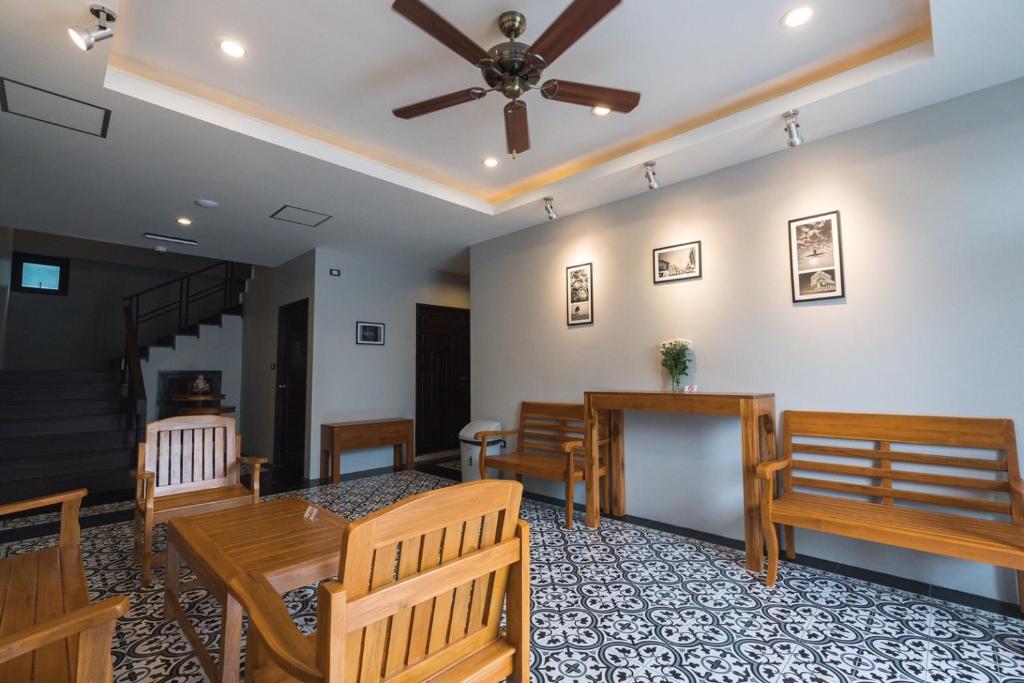 a dining room with wooden chairs and a ceiling fan at The Besavana Phuket - SHA Extra Plus in Phuket Town